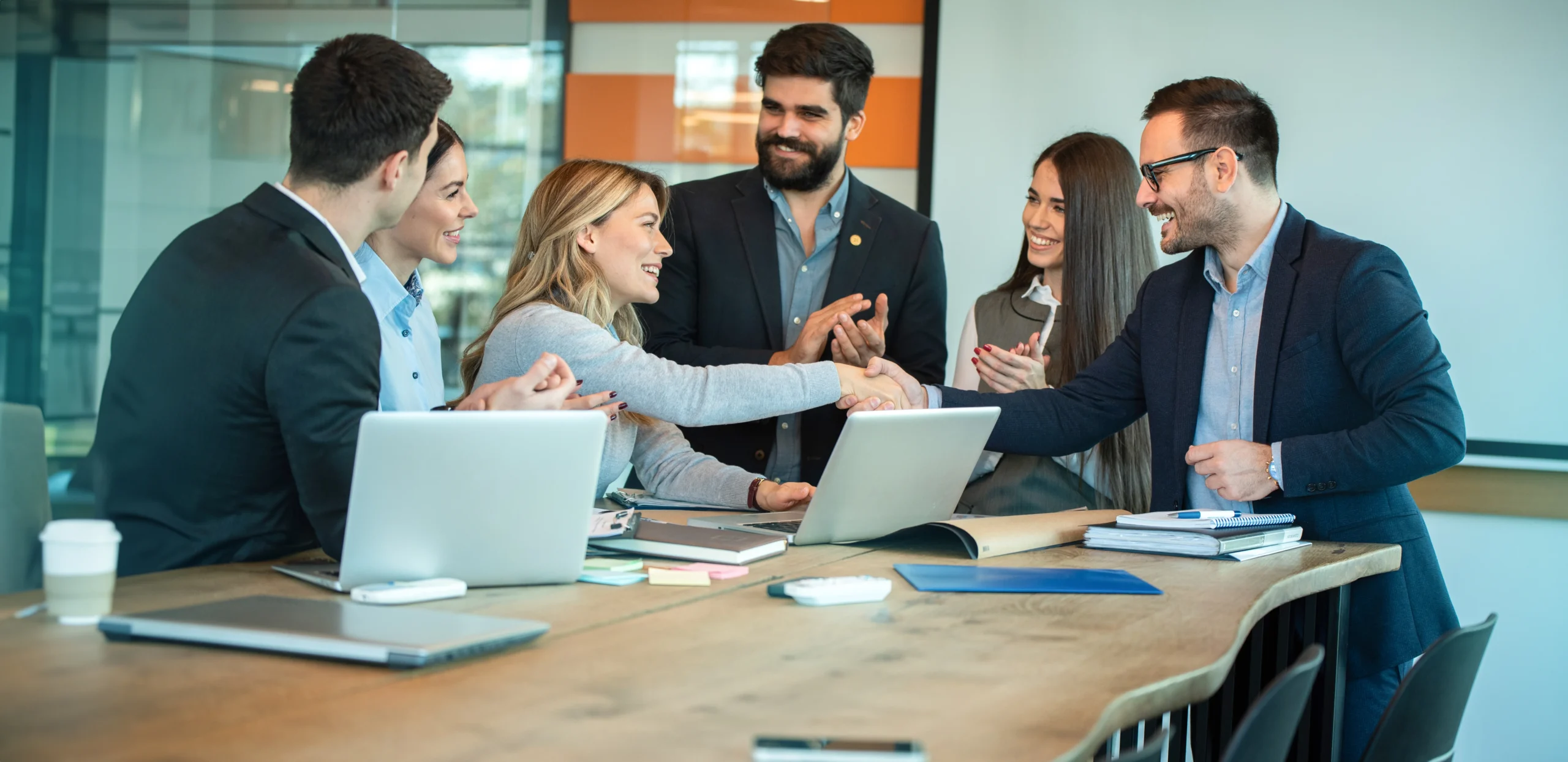 ceo-female-entrepreneur-shaking-hands-with-businessman-while-business-partners-clapping-hands-celebrating-office