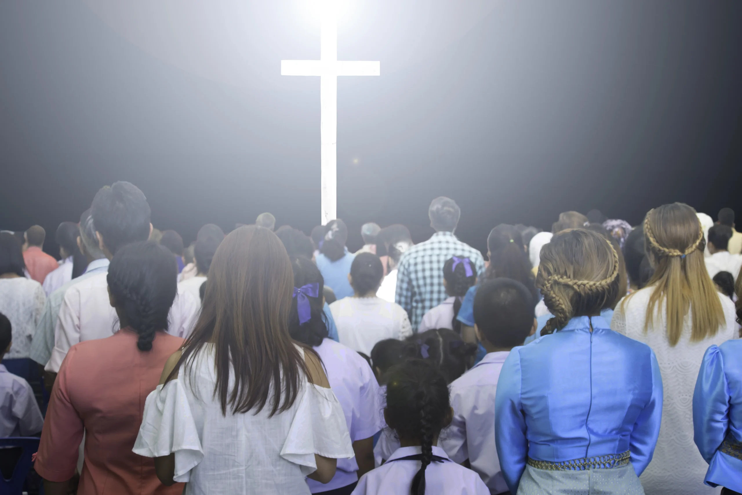 crowd-standing-front-illuminated-cross-night